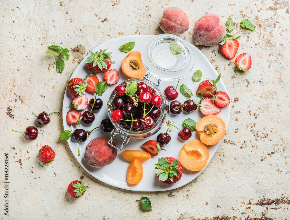 健康的夏季水果品种。甜樱桃、草莓、黑莓、桃子、香蕉和薄荷