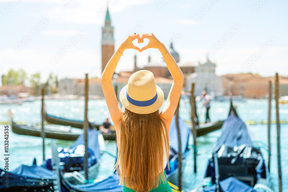 威尼斯美景中的女人用手塑造心形。威尼斯是最受欢迎的景点之一