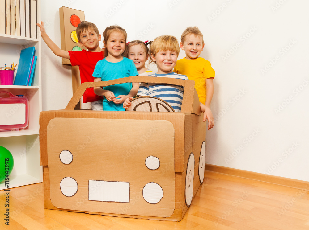 五个微笑的孩子开着手工纸板车