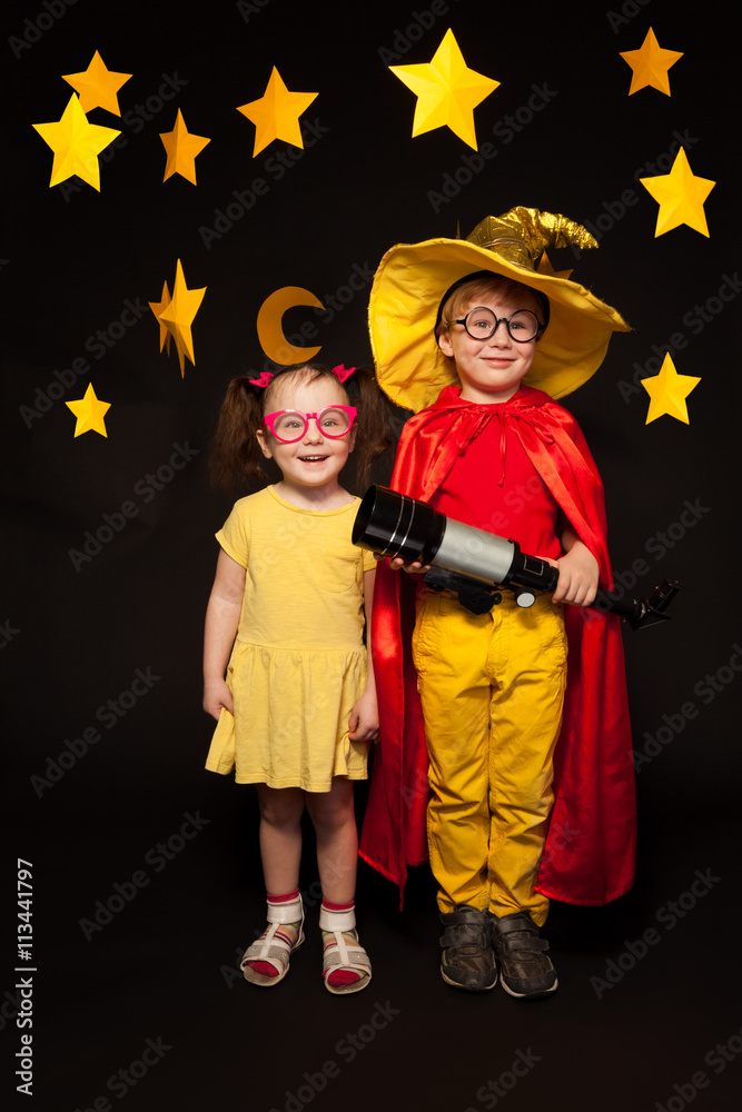 Kids in sky watchers costumes with a telescope