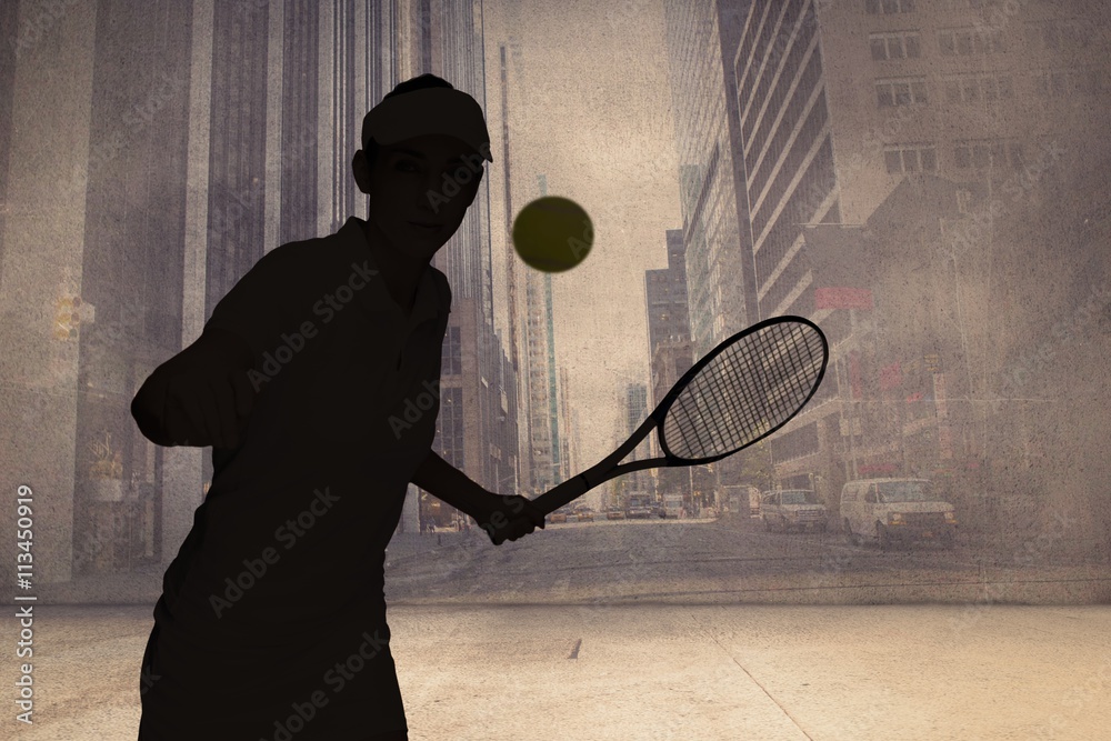 女运动员对抗墙上的城市投影打网球