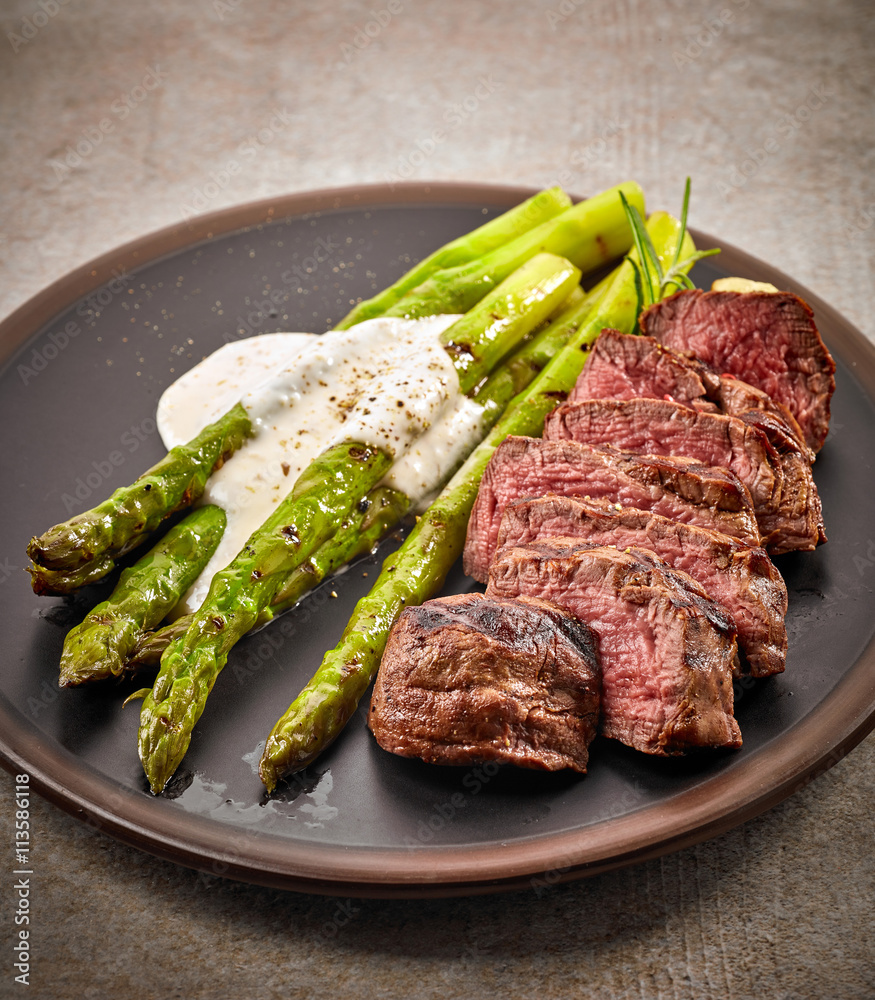 portion of sliced beef steak and asparagus