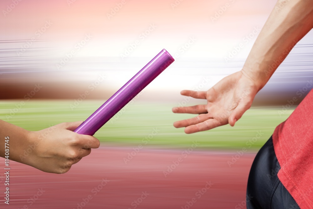 Composite image of athlete passing a baton to the partner