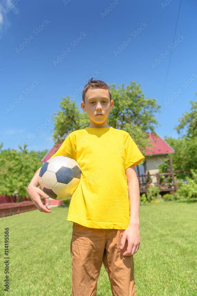 在绿色草坪上踢球的男孩。夏天！