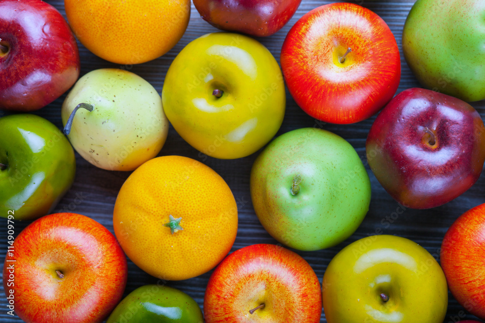 木板背景上的成熟苹果、梨和橙子