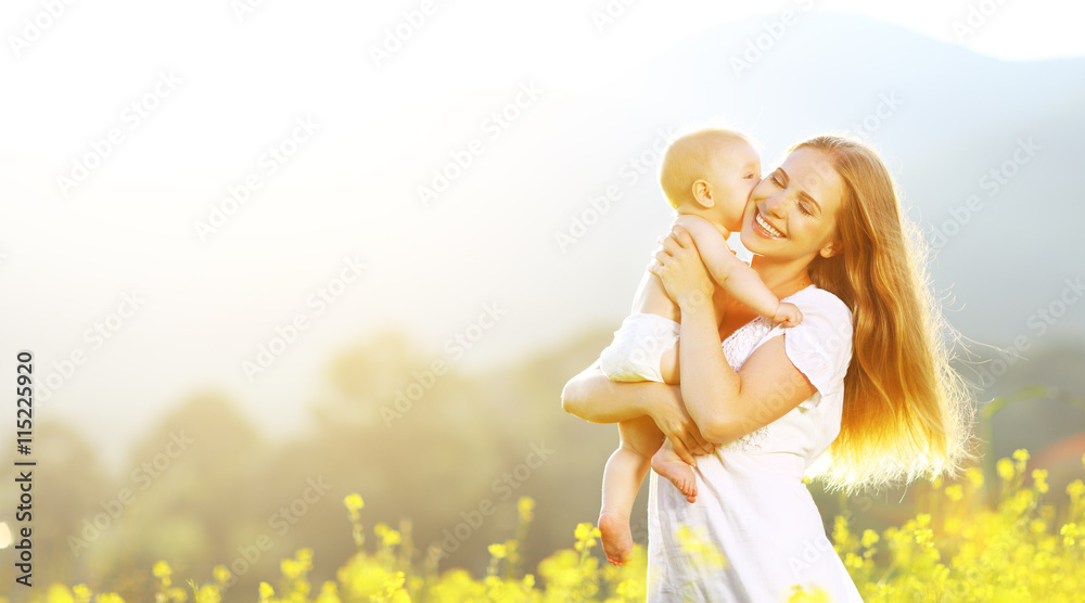 快乐的家庭母亲和婴儿在夏天的自然拥抱和亲吻