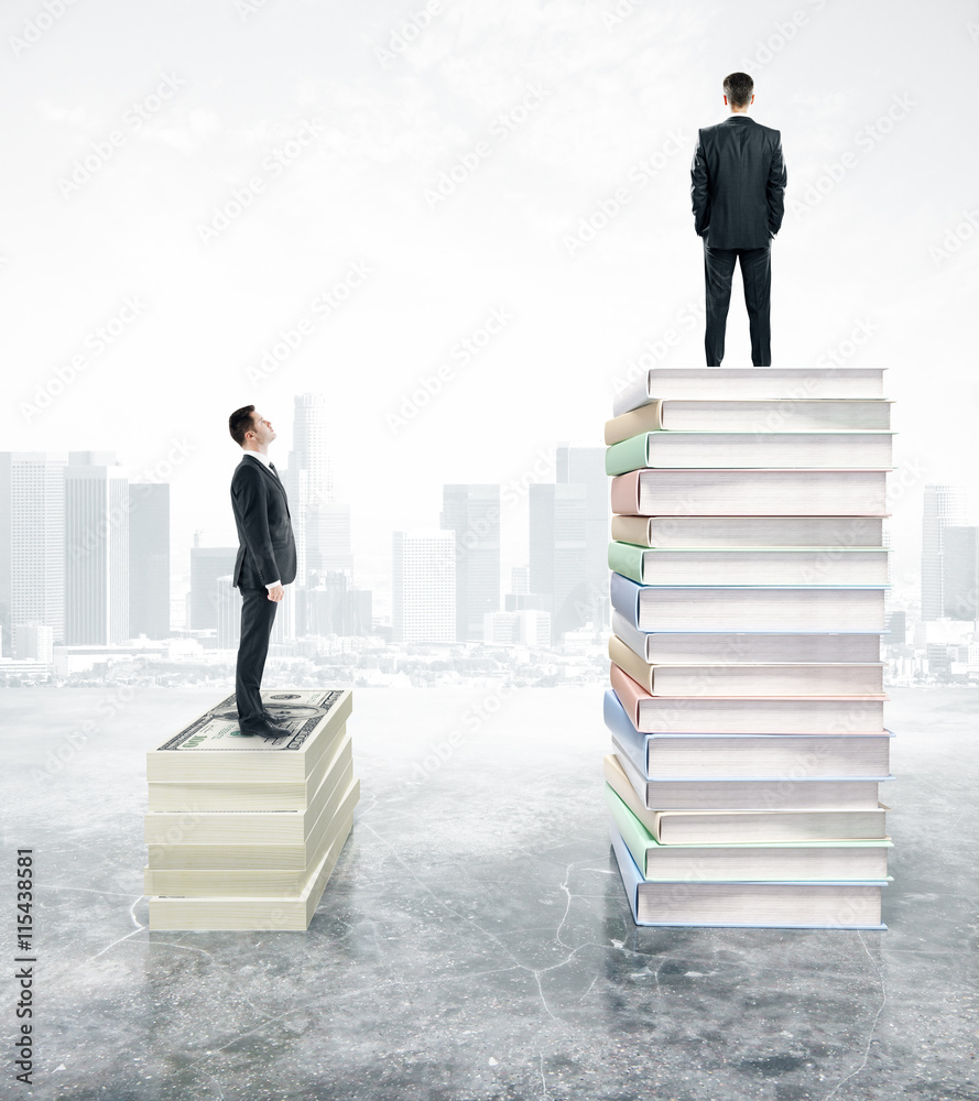 Handsome businessman standing on stack of books