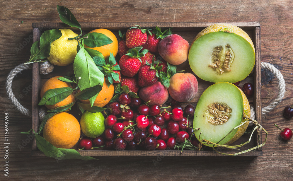 健康的夏季水果品种。甜瓜、甜樱桃、桃子、草莓、橙子和柠檬装在木制t中
