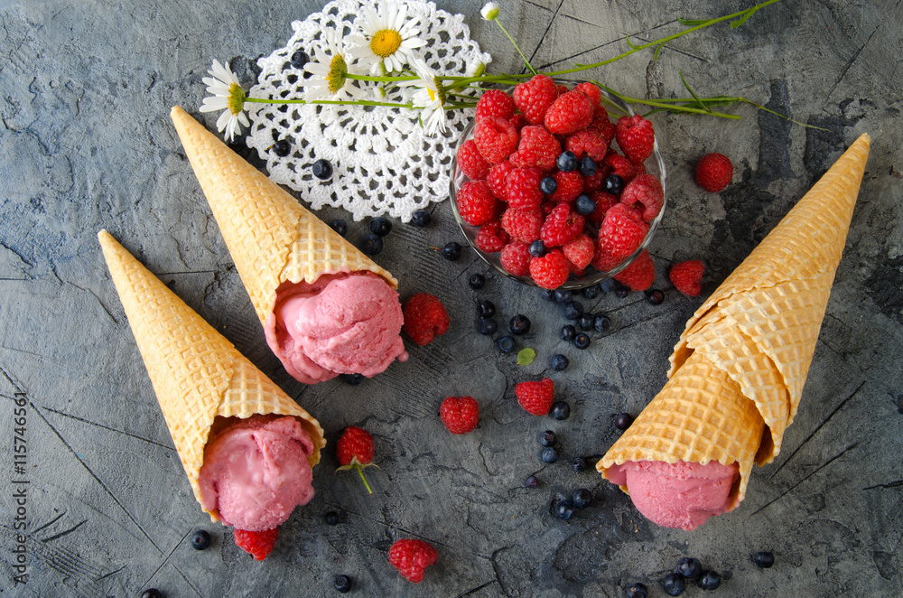 石桌上的树莓冰淇淋配冰淇淋蛋卷。