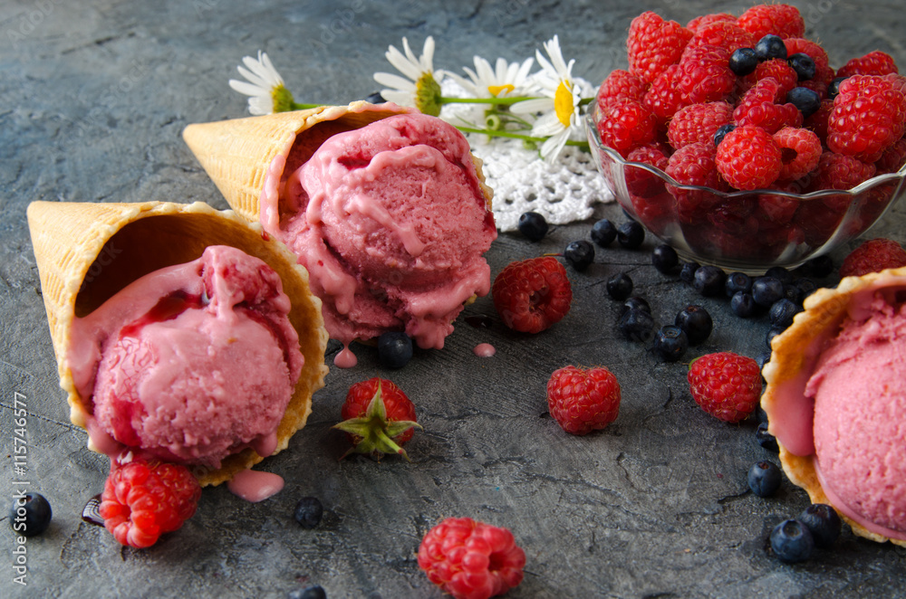 石桌上的树莓冰淇淋配冰淇淋蛋卷。