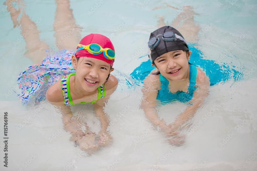 快乐的亚洲兄弟姐妹女孩在游泳池玩耍