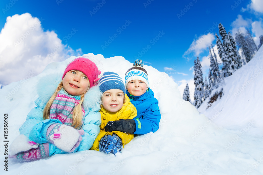 三个小孩在雪洞里微笑