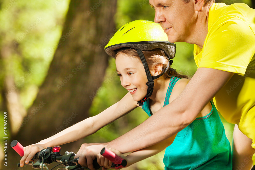 微笑的女孩与父亲一起学习骑行