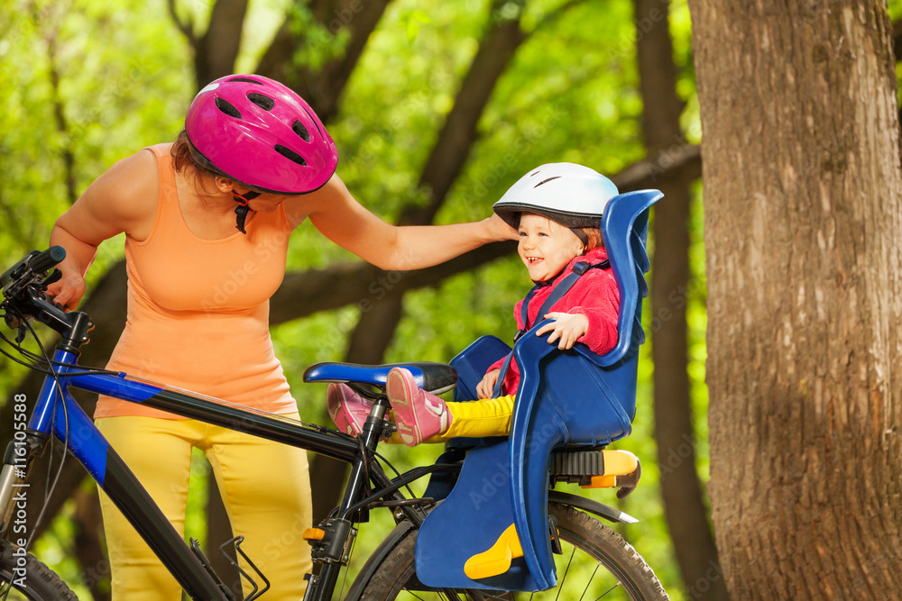 蹒跚学步的女孩和妈妈一起骑自行车玩得很开心