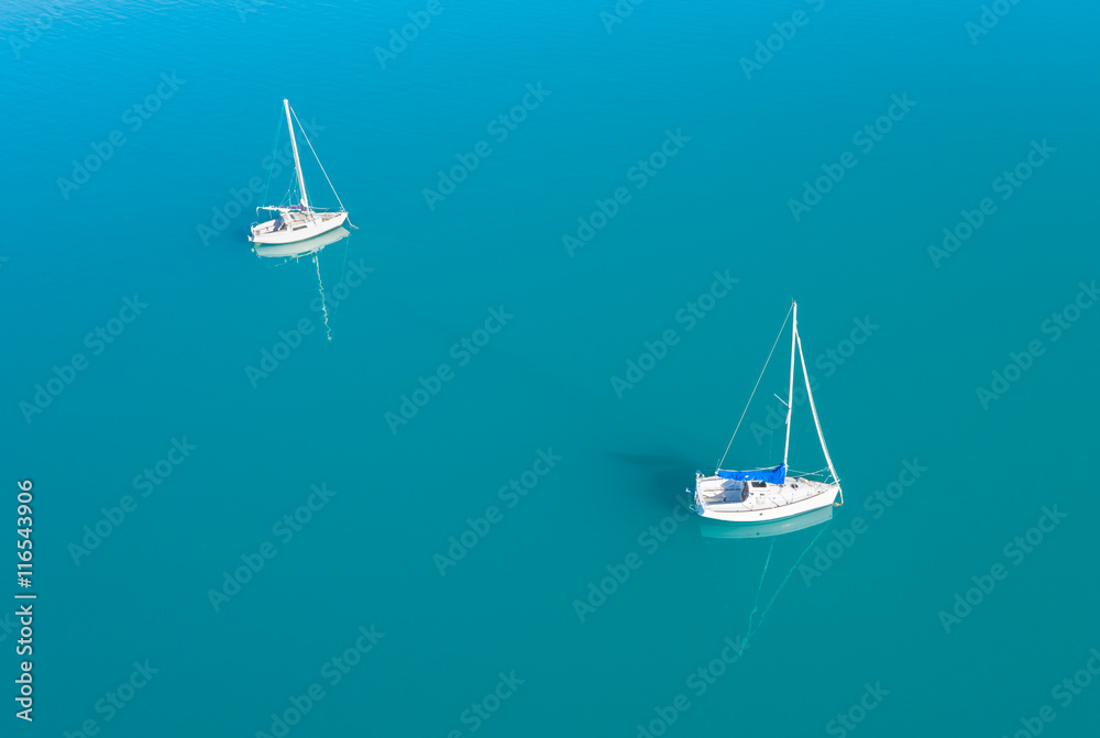 Aerial view of two yachts sailling on azure water