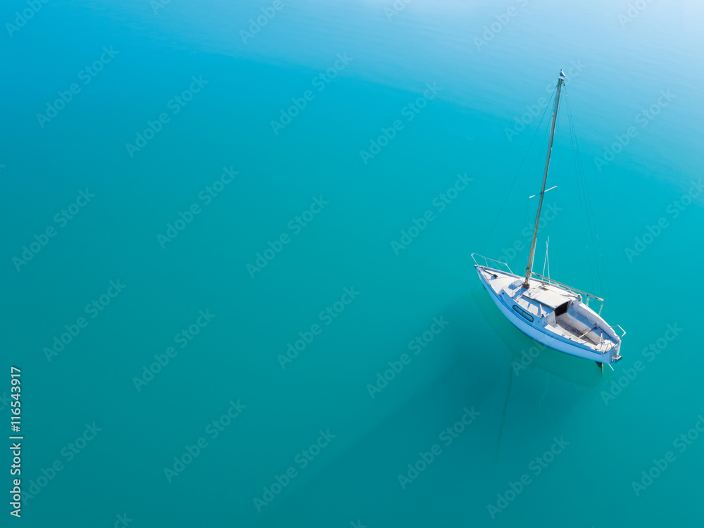 独自一艘游艇在蔚蓝的水面上航行的鸟瞰图