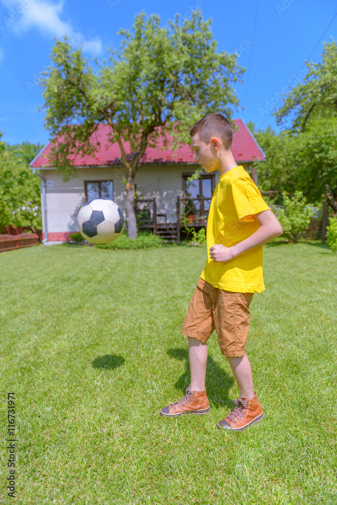 在绿色草坪上打球的男孩。夏天！