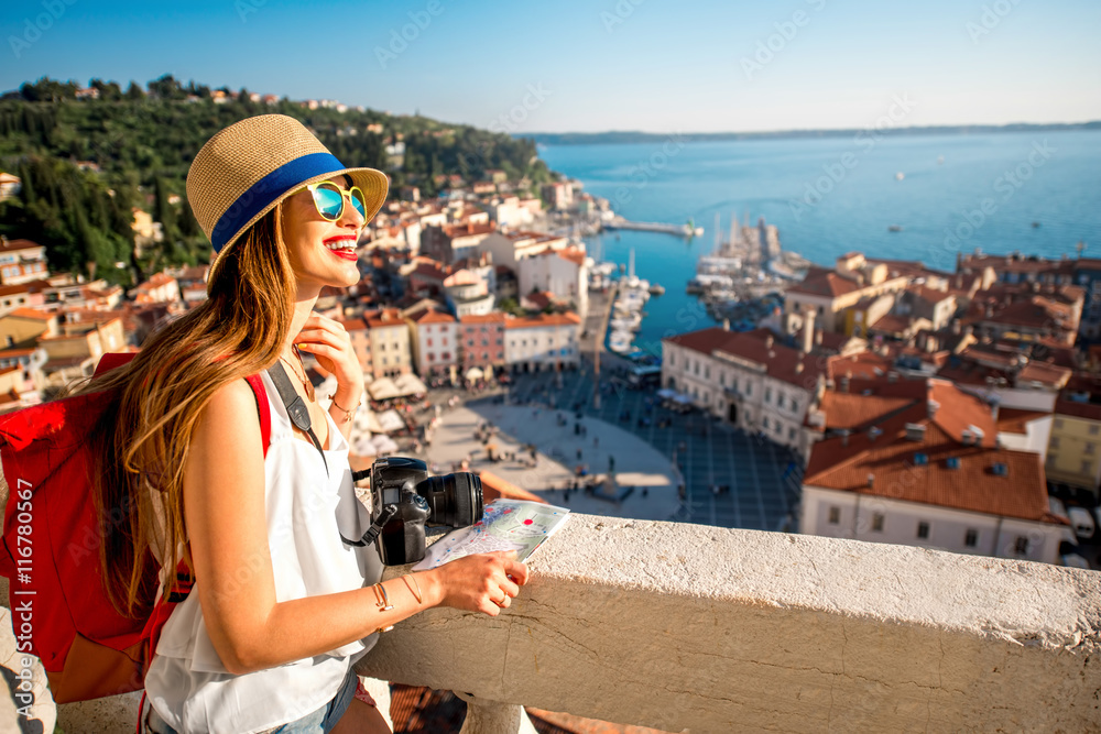 年轻的女旅行者，背着红色背包，戴着帽子，在皮兰老t上欣赏乔治塔的景色