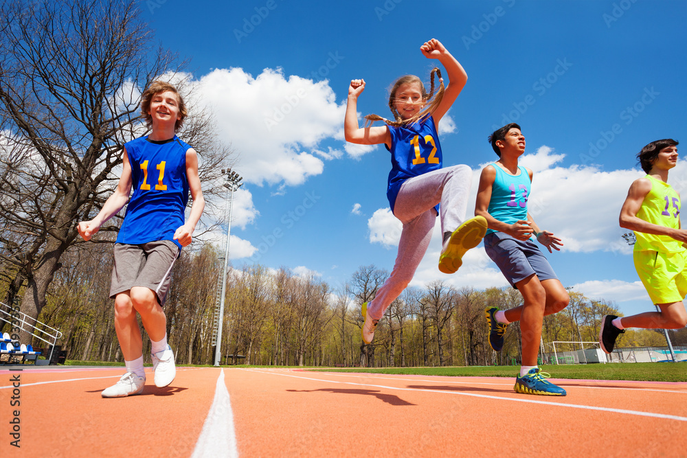 快乐的青少年运动员在体育场里奔跑