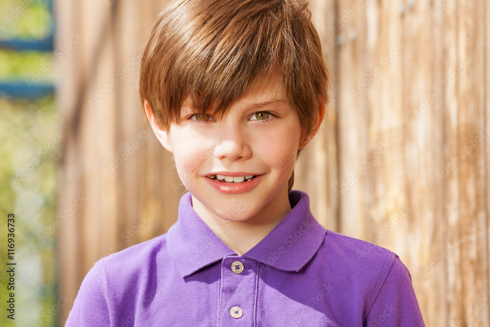 穿着紫色马球衫的十岁男孩的肖像