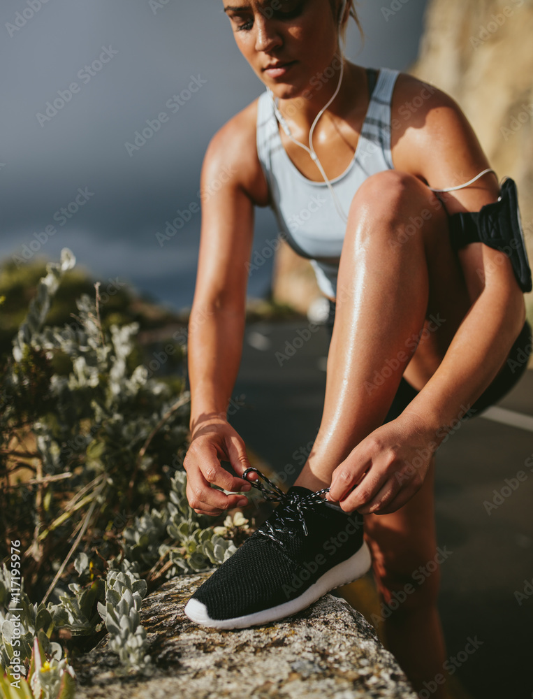 健身女士跑步前系鞋带运动鞋
