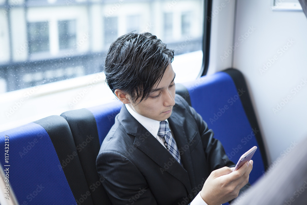 商人在火车上沉迷于智能手机