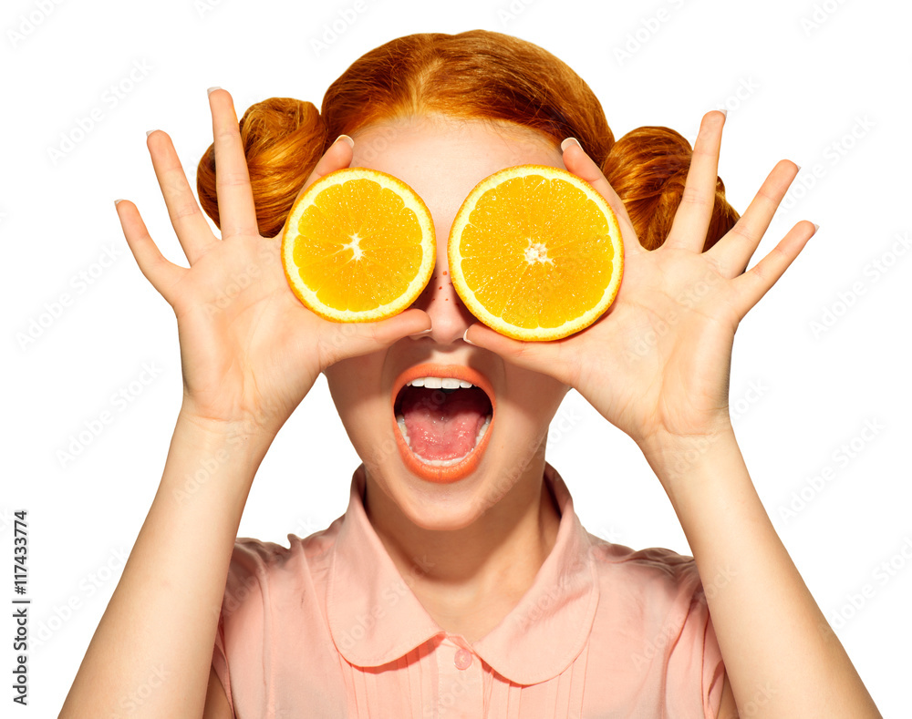 美丽快乐的少女，长着雀斑，手里拿着多汁的橙子