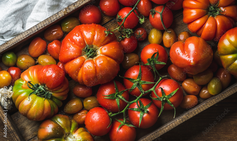 深色木托盘中不同大小和种类的彩色番茄，俯视图，水平构图