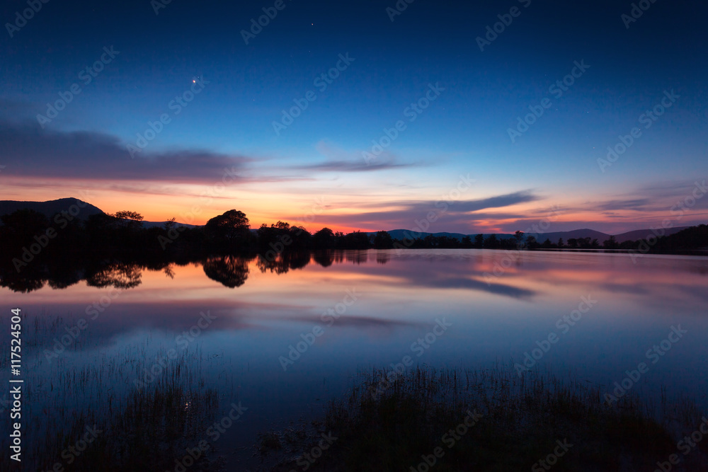 山湖上美丽的夜景，春天的星星和水中的倒影。C