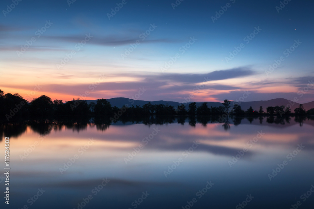 山湖上美丽的夜景，春天的星星和水中的倒影。C