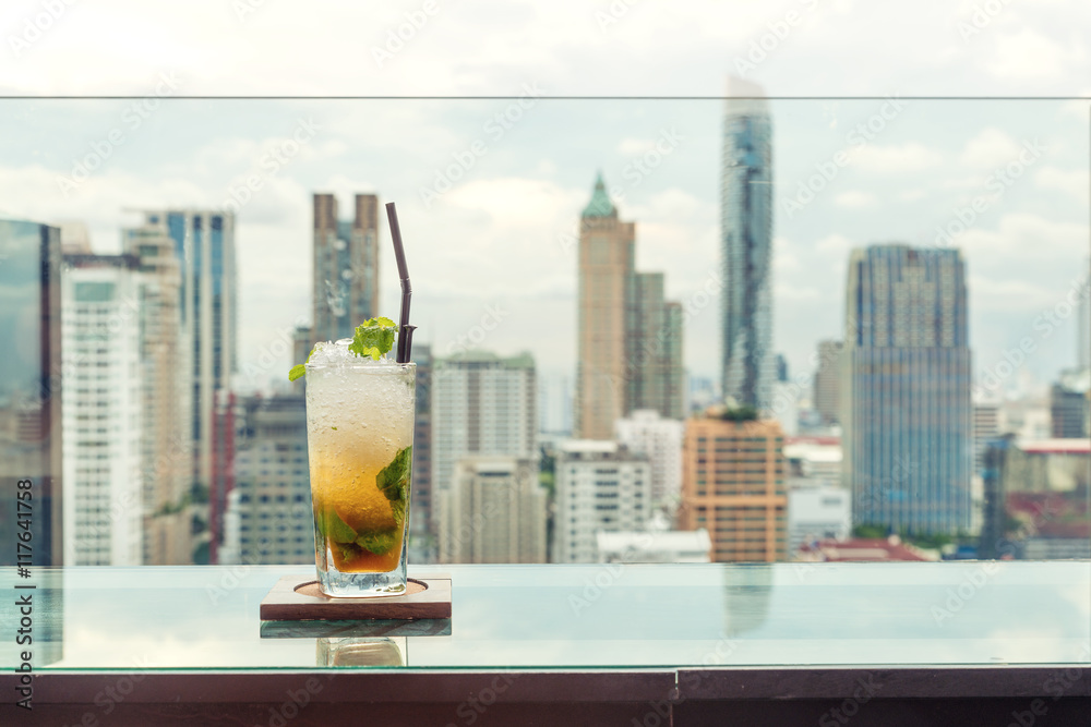 曼谷城市景观屋顶酒吧餐桌上的Mojito鸡尾酒