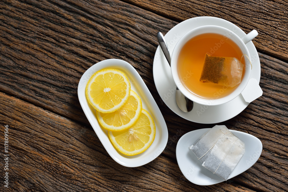 一杯装茶包的茶，茶包柠檬放在木桌上的俯视图