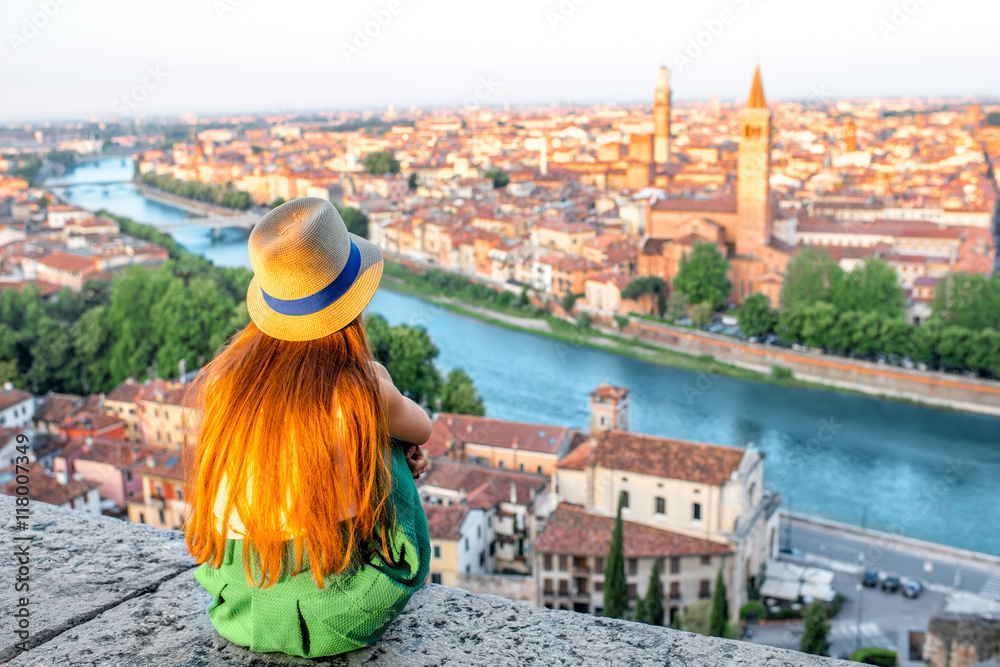 女人在日出时欣赏意大利维罗纳市的美景。维罗纳是著名的爱情之城
