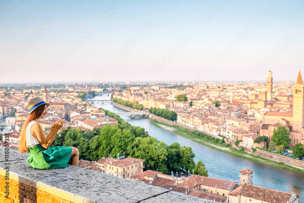女人在日出时欣赏意大利维罗纳市的美景。维罗纳是著名的爱情之城