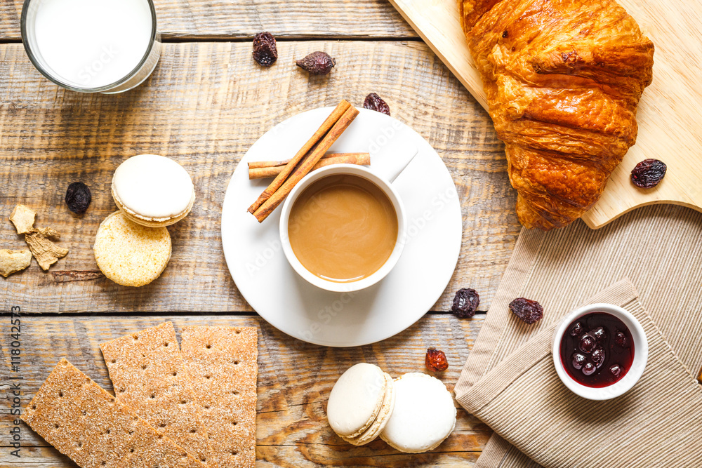 木桌上有咖啡、饼干和羊角面包的早餐