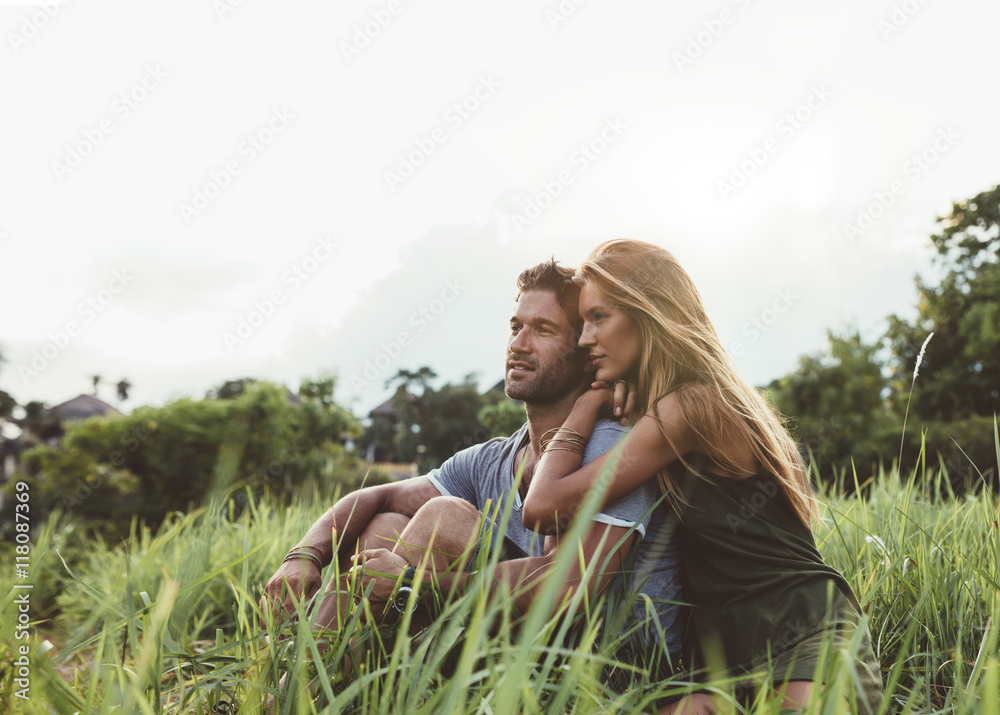 年轻情侣坐在草地上