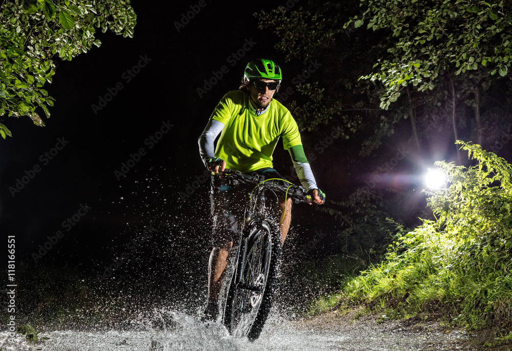 在森林溪流中骑行的山地自行车手