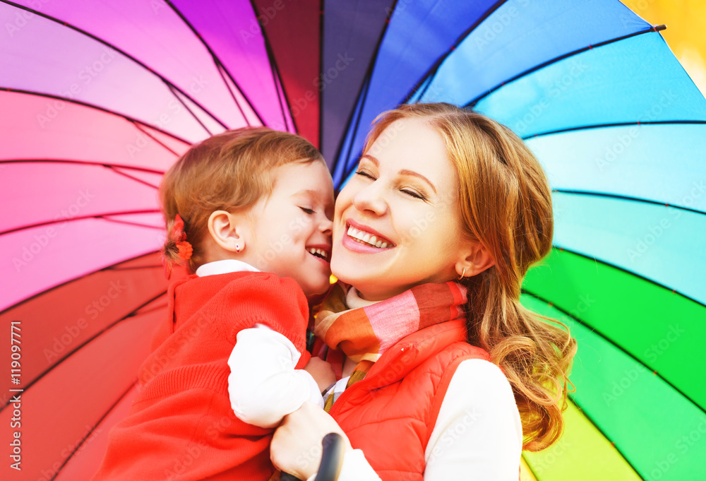 幸福的家庭妈妈和孩子的女儿与彩虹色的umbrell