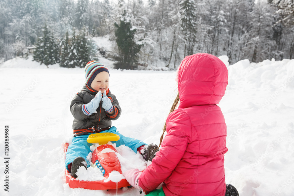 哥哥和姐姐在白雪皑皑的冬季风景中玩耍