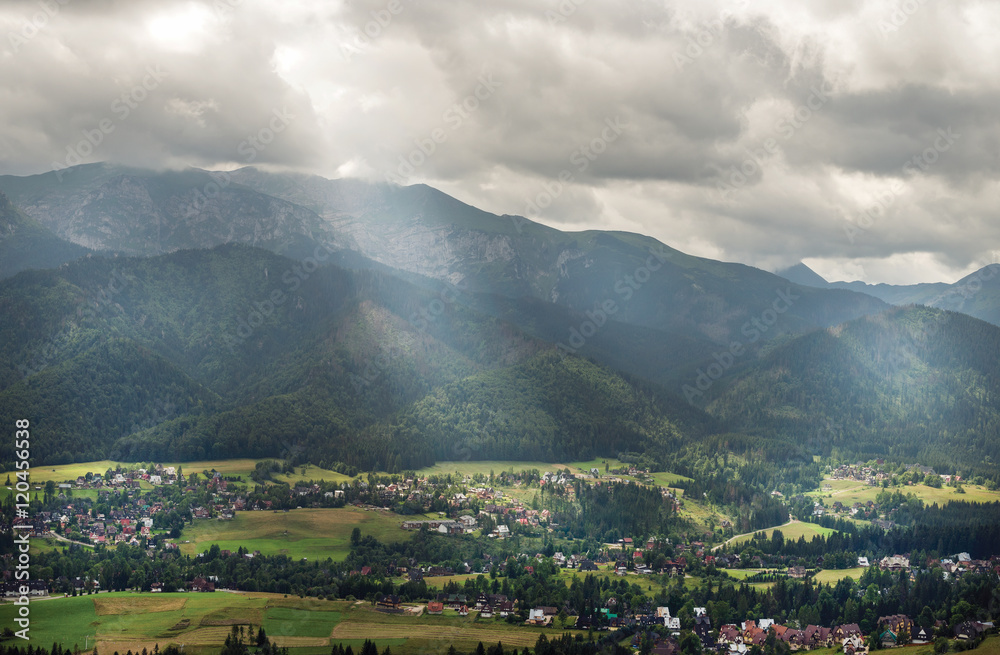 阳光穿过云层，俯瞰绿色的山谷、村庄和山脉。Zakopane，Tatr