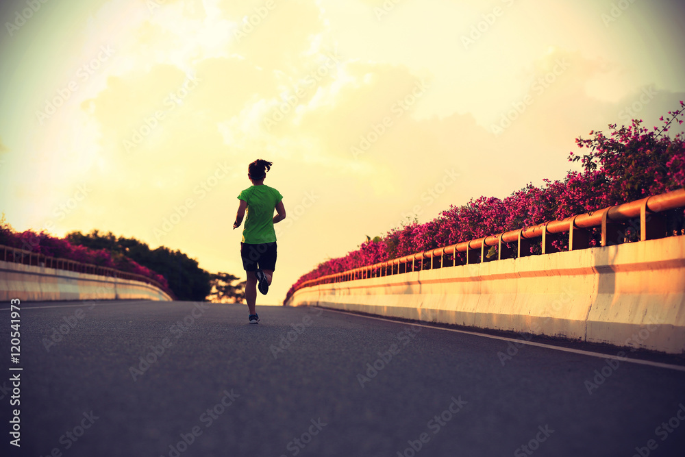 年轻女跑步者在城市桥梁上奔跑