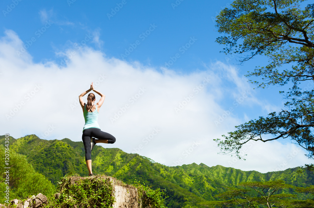女人在美丽的自然环境中做瑜伽运动。
