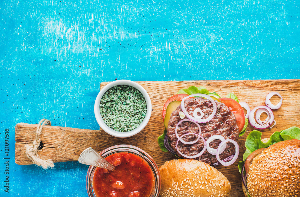 自制牛肉汉堡，配洋葱、新鲜蔬菜和番茄酱，在木板上放在blu上