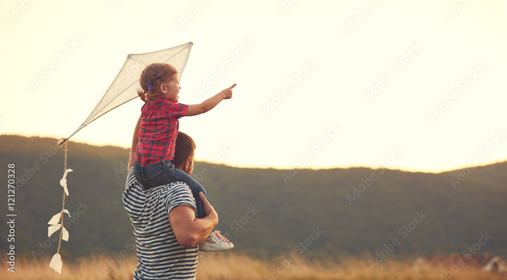 快乐的家庭父亲和孩子在草地上放风筝