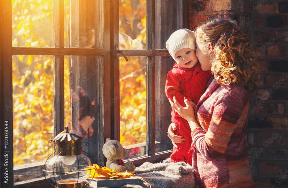 幸福的家庭母亲和婴儿在f的窗户边玩耍和大笑