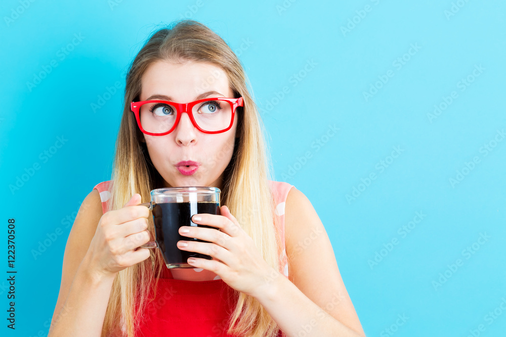 Happy young woman drinking coffee