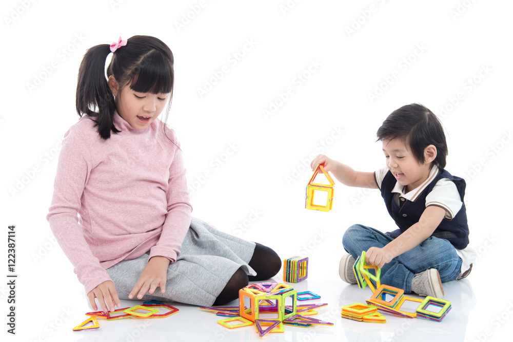 亚洲孩子玩很多五颜六色的磁铁塑料块