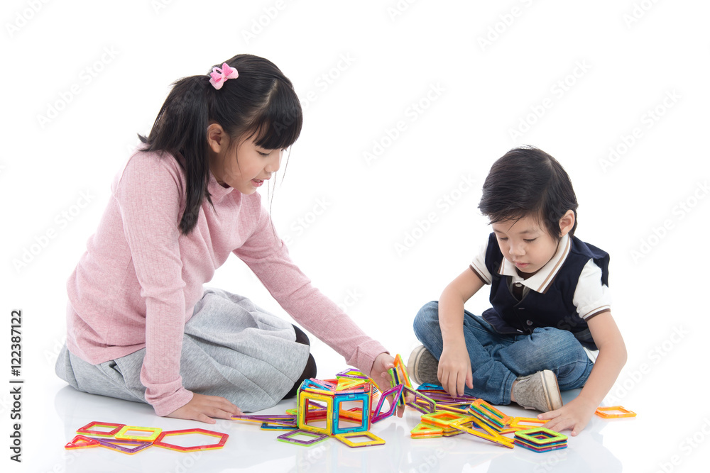 亚洲儿童玩很多五颜六色的磁铁塑料块