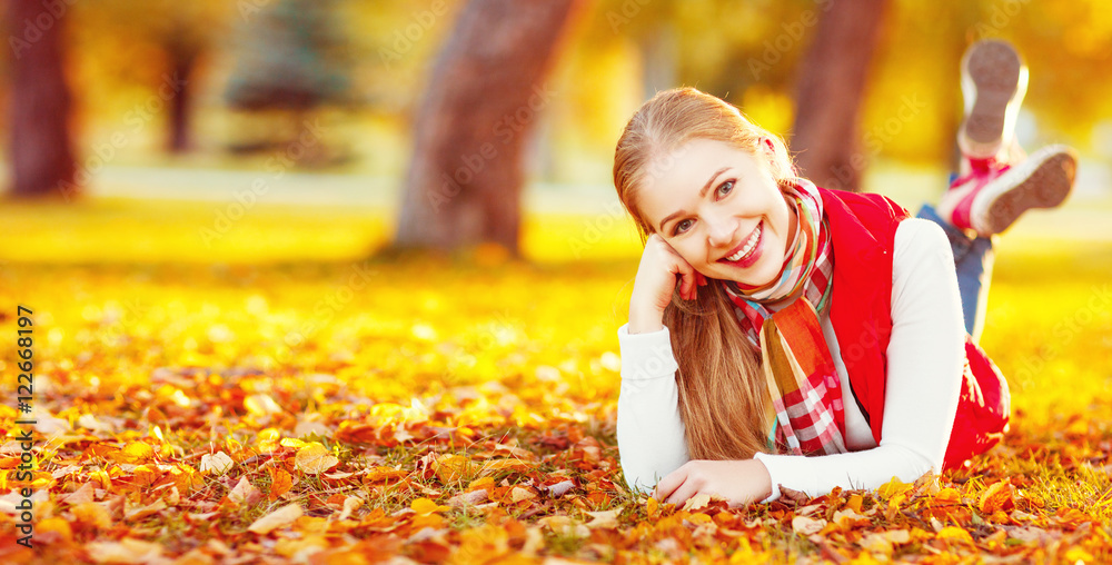 快乐的年轻女人在秋天户外休息