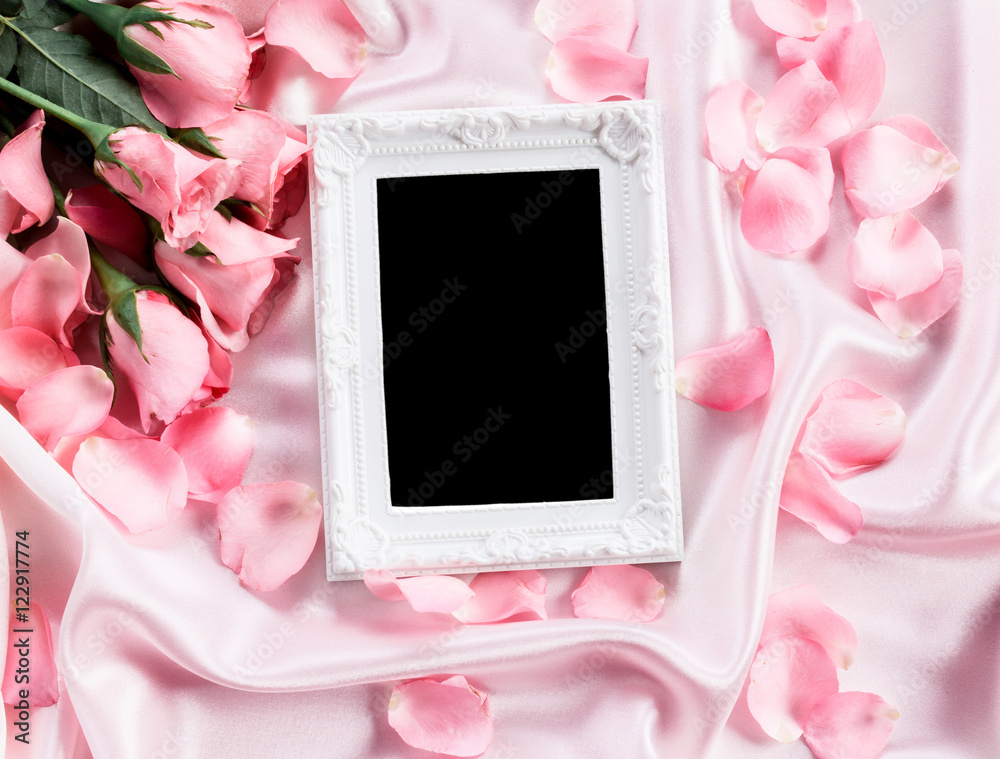 空相框，柔软的粉色丝绸面料上有一束甜美的粉色玫瑰花瓣，浪漫而可爱
